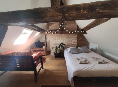 - une chambre avec un lit et une chaise dans l'établissement Habitation Saint-Clar Vieille Ville, à Bergerac