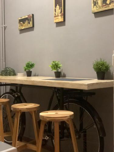 a table with stools and potted plants on it at Hostel Sova in Novi Sad