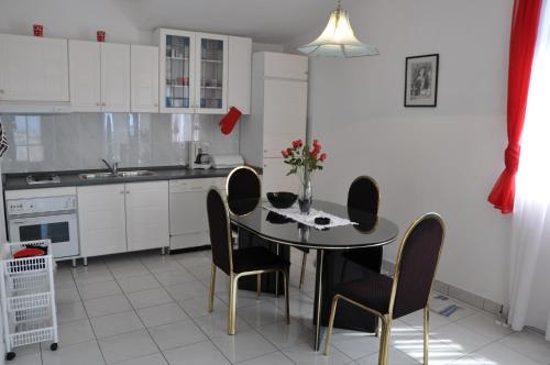 a kitchen with a table and chairs in a kitchen at Apartmani Antunović Podgora in Podgora
