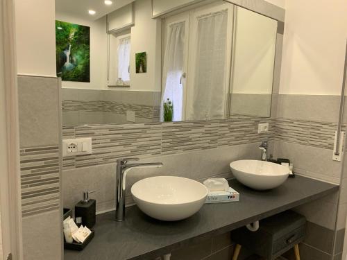 bagno con 2 lavandini e specchio di CEJM Apartments Merano a Merano