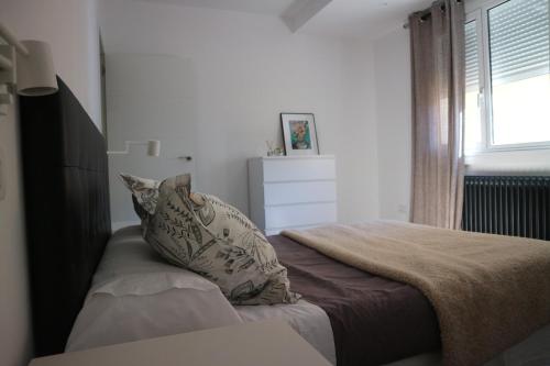 1 dormitorio con cama con almohada y ventana en FOROPLAZA Porta San Pedro Pleno Centro Vistas Muralla, en Lugo