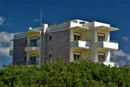 a building on top of a hill with trees at Astronomy Studios in Faliraki