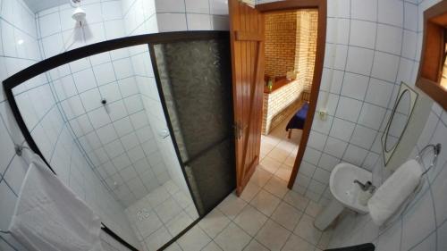a bathroom with a shower and a toilet at Pousada Maunaloa in Garopaba