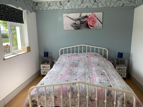 1 dormitorio con cama con colcha en Windmill cottage, en Donegal