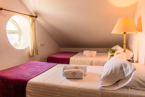 two beds in a room with a window at Villa Guadalupe in Málaga