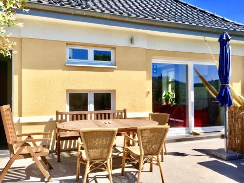 una mesa de madera con sillas y una sombrilla azul en Maisonette Wohnung Südstadtvilla, en Eisenach