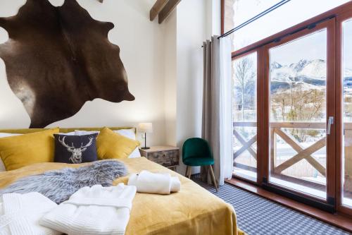 a bedroom with a bed and a large window at Chalets Royal, Tatranská Lomnica in Tatranská Lomnica