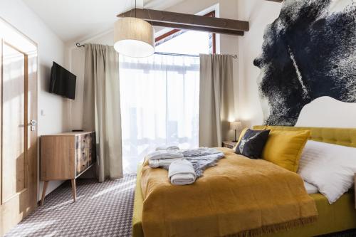 a bedroom with a yellow bed and a large window at Chalets Royal, Tatranská Lomnica in Tatranská Lomnica