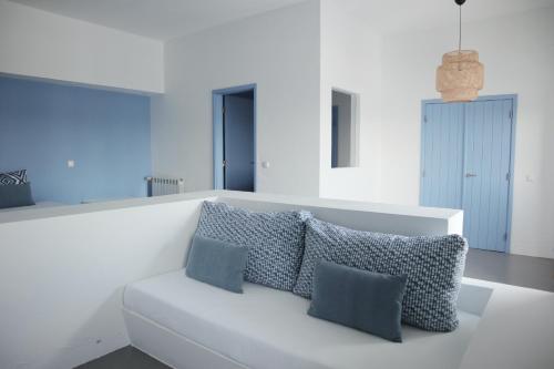 a white couch with three pillows on it in a room at Casas do Sal in Alcácer do Sal