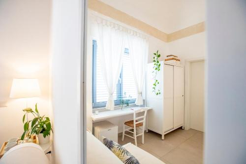 a white room with a desk and a window at La Casa Della Zia in San Pancrazio Salentino