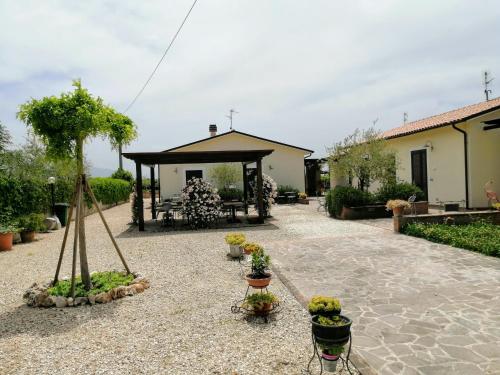 a garden with a pavilion with potted plants at Residence Terra Dei Santi Country House in Spello