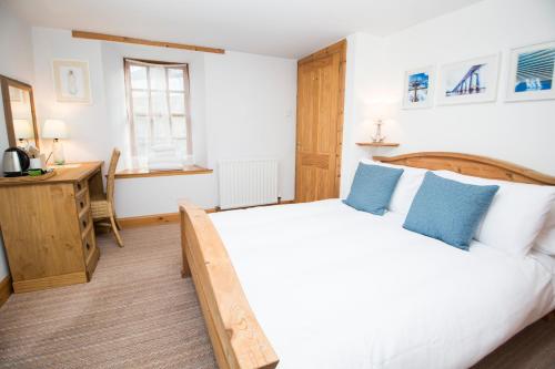 1 dormitorio con cama y escritorio en The Old Boathouse, en Wormit