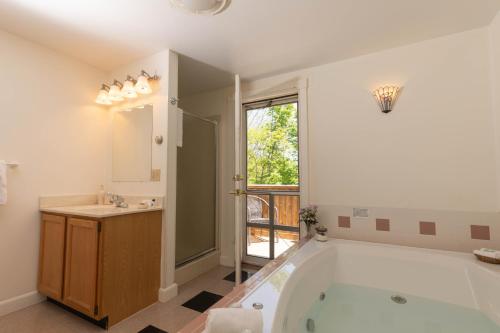 a bathroom with a tub and a sink and a mirror at Maple Hill Farm Inn in Augusta