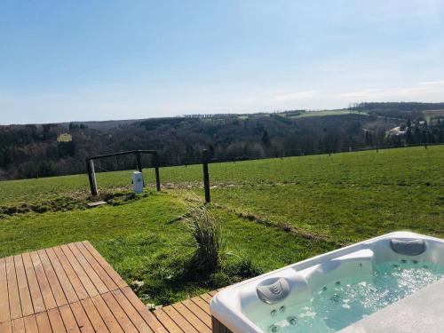 une baignoire assise sur une terrasse dans un champ dans l'établissement Lodge spa, à Petit-Réderching