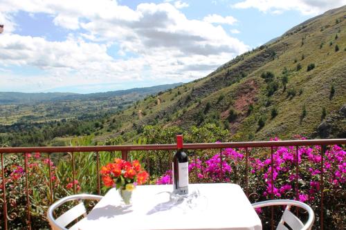 a bottle of wine sitting on a table with flowers at Suites Arcoiris in Villa de Leyva