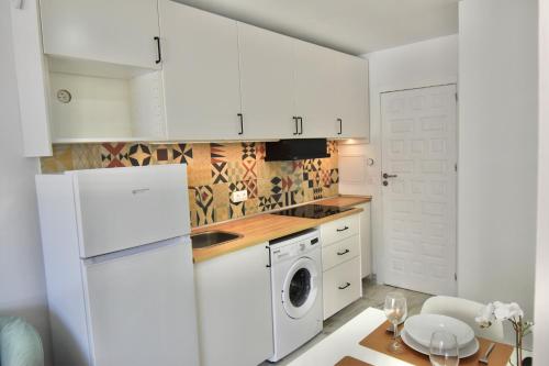 ネルハにあるStudio Torresol Nerjaのキッチン(白いキャビネット、洗濯機、乾燥機付)