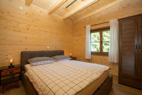 a bedroom with a bed in a wooden cabin at Holiday home Natura in Slunj