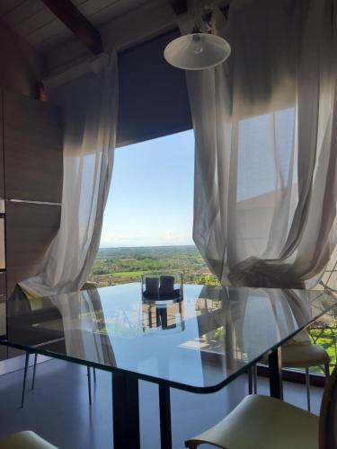 a glass table in a room with a large window at Agriturismo CasaMatilda in Dogliani