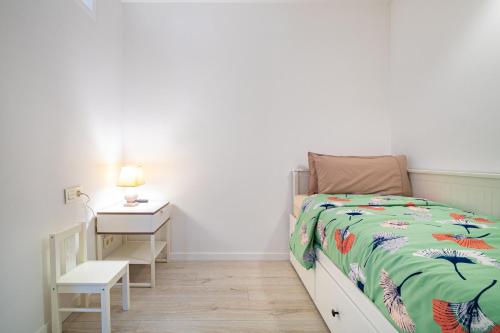 a white bedroom with a bed and a night stand at Comtal homey apartments in Barcelona