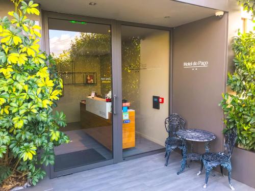a glass door with two chairs and a table outside at Hotel do Paço By VimaHotels in Guimarães