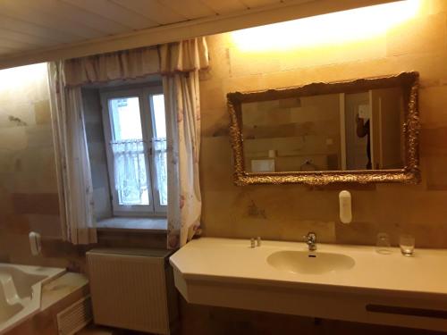 a bathroom with a sink and a mirror and a window at Hotel Feiler in Muggendorf