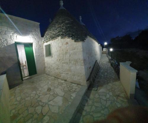 a stone building with a green door at night at Trullo Le Tre Sorelle in Cisternino