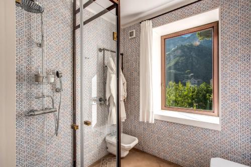 un bagno con doccia, WC e finestra di Casa Massa Amalfi ad Amalfi
