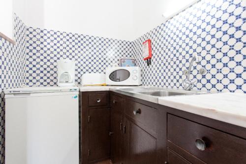 una cucina con lavandino e forno a microonde di Apartamentos Turisticos Marsol a Lagos