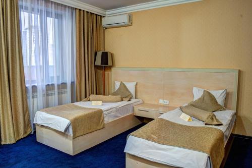 a hotel room with two beds and a window at King Hotel Astana in Astana