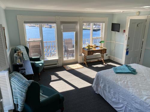 a bedroom with a bed and a view of the ocean at The Tuna Blue Inn in Hubbards
