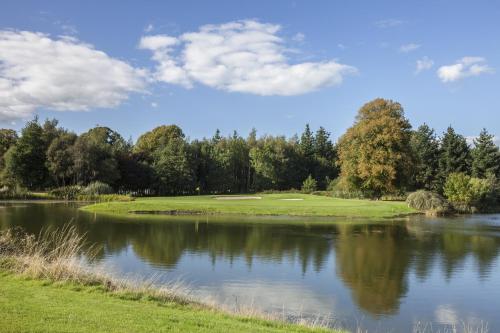 a golf course with a lake in the foreground at Fota Island Hotel and Spa in Cork