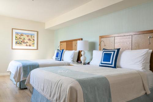 two beds in a hotel room with blue and white at Gateway Hotel Santa Monica in Los Angeles
