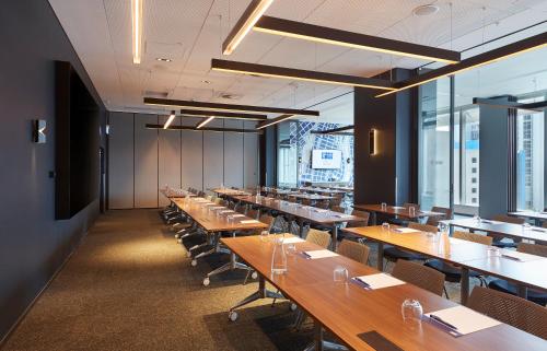 a large dining room with long tables and chairs at Holiday Inn Express Melbourne Southbank by IHG in Melbourne