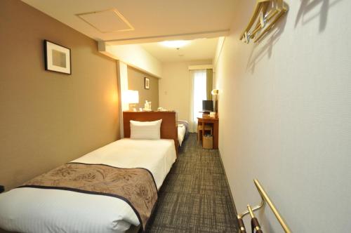 a room with two beds in a hotel room at Hotel Hokke Club Kumamoto in Kumamoto