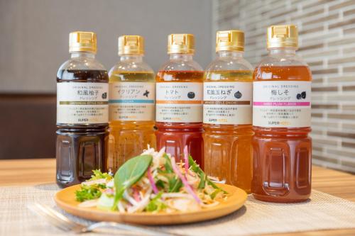 a group of bottles of honey and a plate of salad at Super Hotel Beppu Ekimae in Beppu