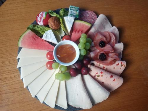 a plate of cheese and fruit on a table at Pension Waldfrieden in Thale