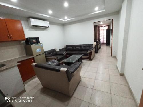 a living room with couches and a table and a kitchen at HS Global Apartments in Rawalpindi