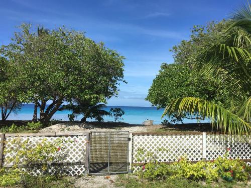 a fence with trees and the ocean in the background at LE FARE BLEU Tiputa Rangiroa in Tiputa