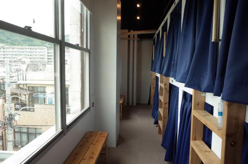 a hallway with blue curtains and a window at bnb+Atami Resort in Atami