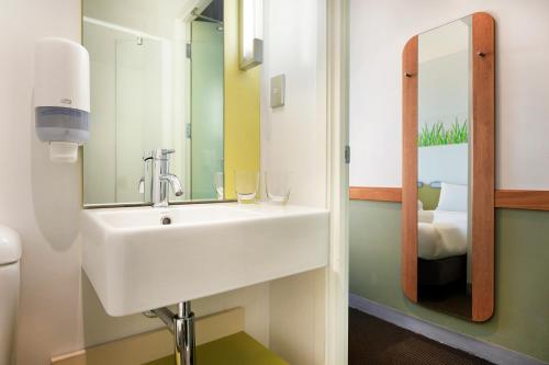 
a bathroom with a sink and a mirror at ibis Budget Auckland Airport in Auckland
