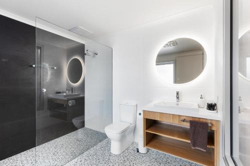 ein Badezimmer mit Toilette, Waschbecken und Spiegel in der Unterkunft City Courtyard Two Apartment in Mount Gambier