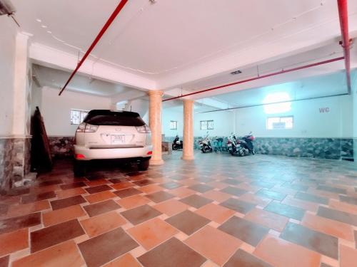 a parking lot with a car parked in a room with motorcycles at Thu Ha Hotel in Uông Bí