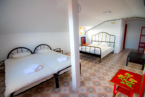 a bedroom with two beds and a red table at Piovra in Vama Veche