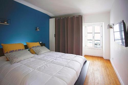 une chambre avec un grand lit blanc avec des murs bleus dans l'établissement CosyHome du MARCHOUX, à Fontenay-le-Comte