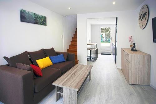 - un salon avec un canapé brun et une table en bois dans l'établissement CosyHome du MARCHOUX, à Fontenay-le-Comte