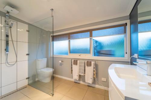 uma casa de banho com um chuveiro, um WC e um lavatório. em Platypus Waters B&B em Smithton