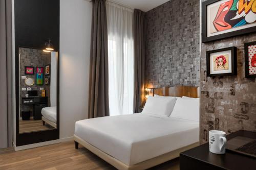 a bedroom with a white bed and a mirror at Up Hotel in Rimini