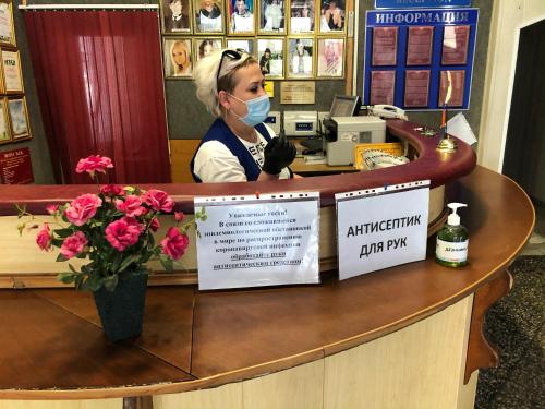 a woman wearing a face mask behind a counter at Гостиница ИЛЕК in Aktobe