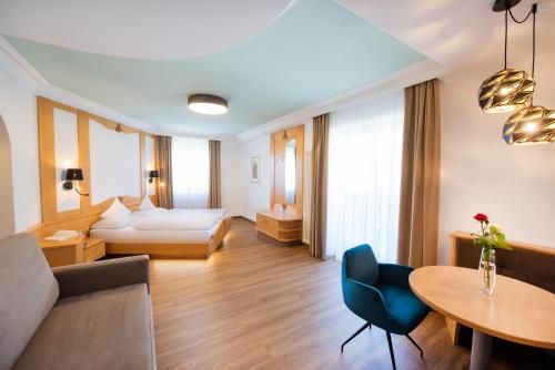 una habitación de hotel con una cama y una mesa en Garni Luziafeld Hof, en Appiano sulla Strada del Vino