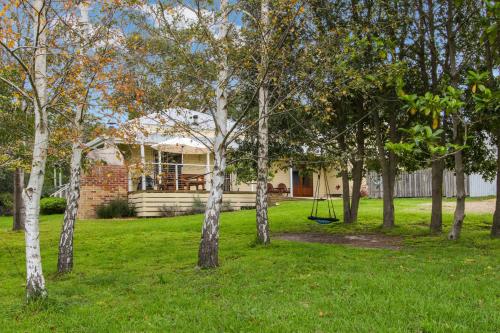 a house with a yard with trees and a swing at Country House Retreat in Nungurner